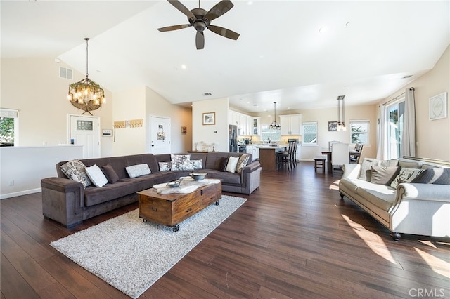 living room with dark wood-type flooring, ceiling fan, lofted ceiling, and plenty of natural light