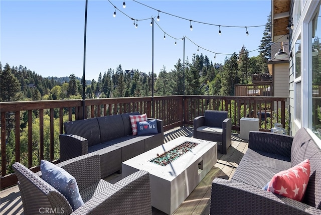 wooden deck featuring an outdoor living space with a fire pit