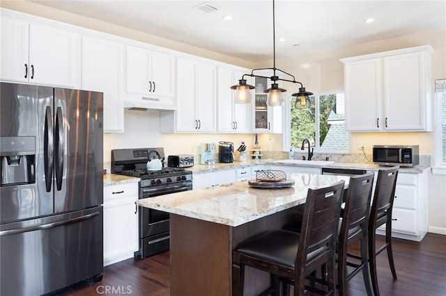 kitchen featuring white cabinetry, a center island, appliances with stainless steel finishes, and dark hardwood / wood-style flooring