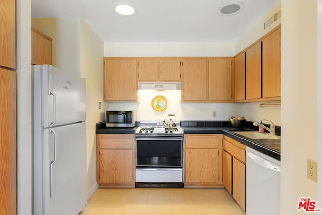 kitchen with light tile patterned flooring, white appliances, sink, and light brown cabinets