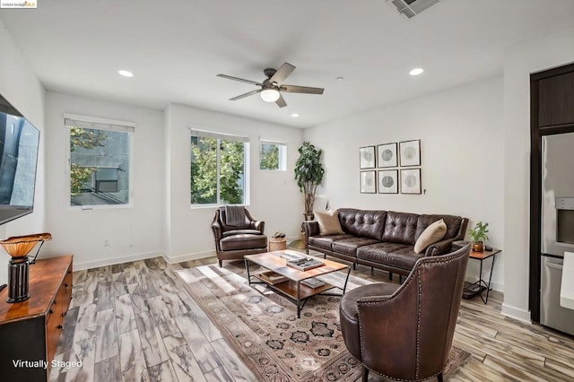 living room with ceiling fan and light hardwood / wood-style flooring