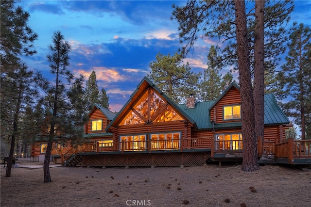 back house at dusk with a deck