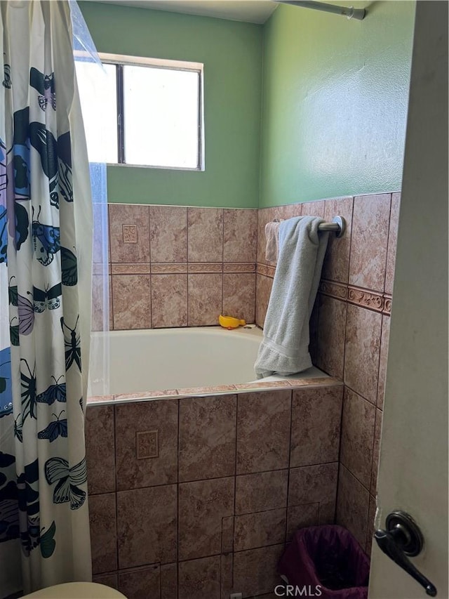 bathroom featuring toilet and shower / bath combo with shower curtain