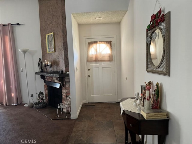 carpeted entryway with a fireplace and a textured ceiling