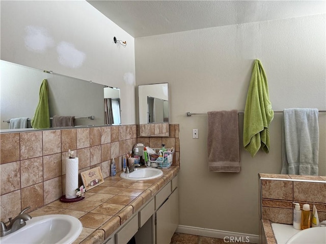 bathroom featuring vanity and tasteful backsplash