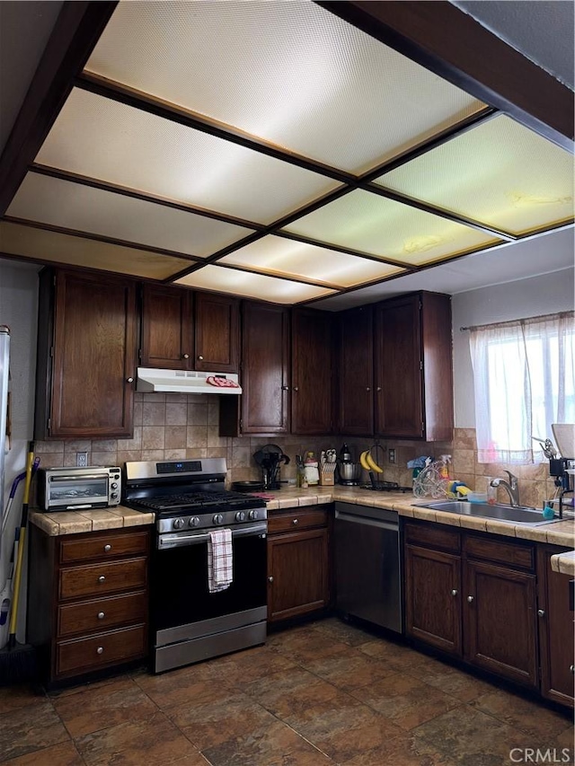 kitchen featuring dark brown cabinets, stainless steel appliances, tasteful backsplash, and sink