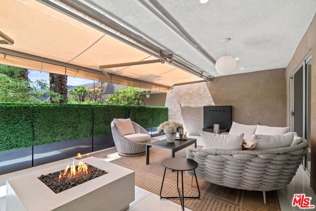 view of patio with an outdoor living space with a fire pit