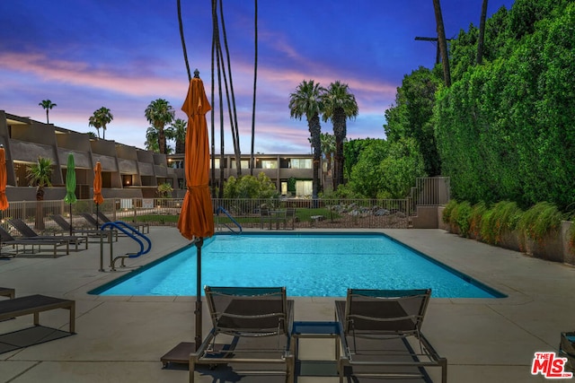 pool at dusk with a patio