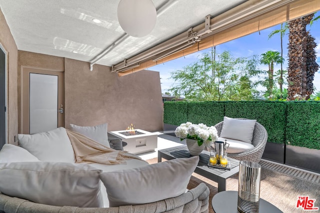 view of patio with an outdoor living space with a fire pit