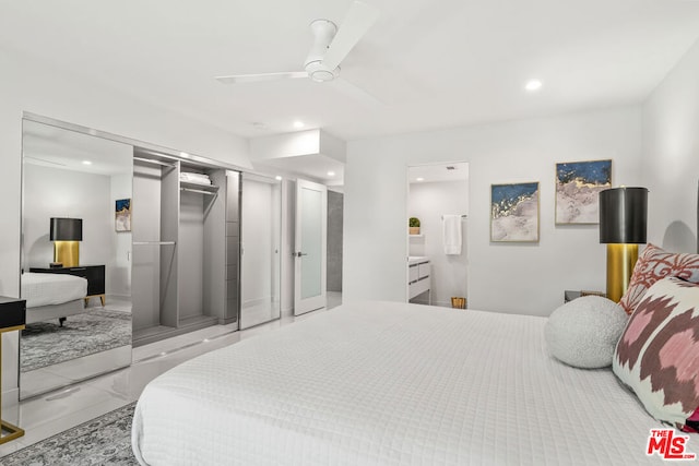 bedroom featuring a closet, ensuite bath, and ceiling fan