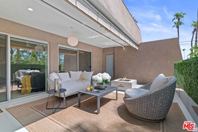 view of patio / terrace with an outdoor living space with a fire pit