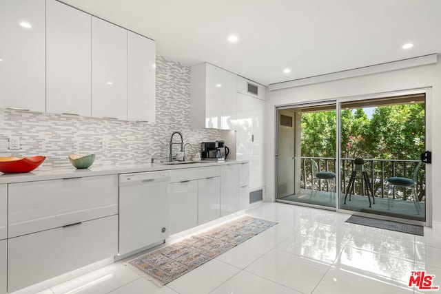 kitchen with tasteful backsplash, light tile patterned floors, white cabinetry, white dishwasher, and sink