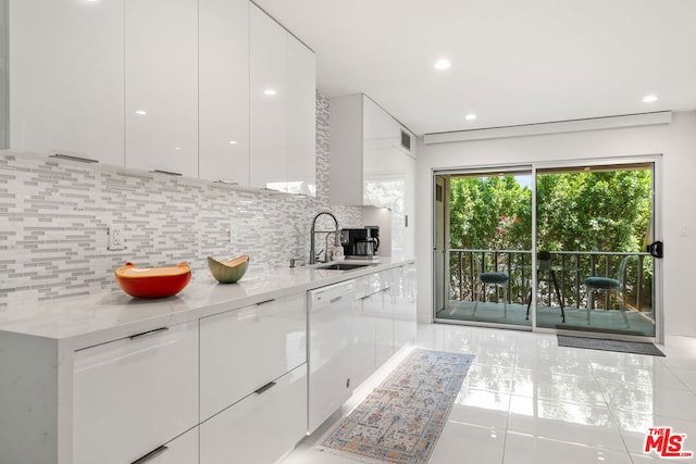 kitchen featuring decorative backsplash, white cabinets, white dishwasher, sink, and light stone counters