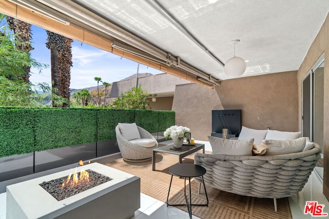 view of patio / terrace with an outdoor living space with a fire pit