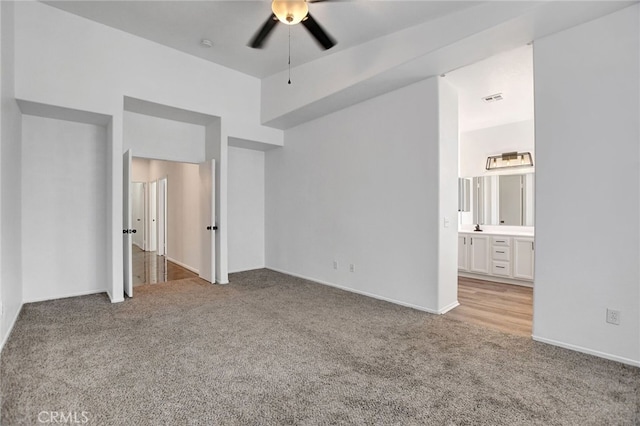 unfurnished bedroom featuring ensuite bathroom, light carpet, and ceiling fan