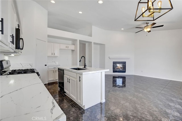 kitchen featuring black appliances, sink, hanging light fixtures, white cabinetry, and a kitchen island with sink