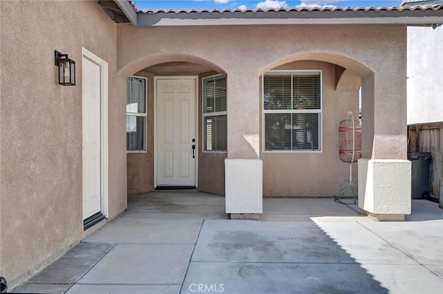 view of exterior entry featuring a patio