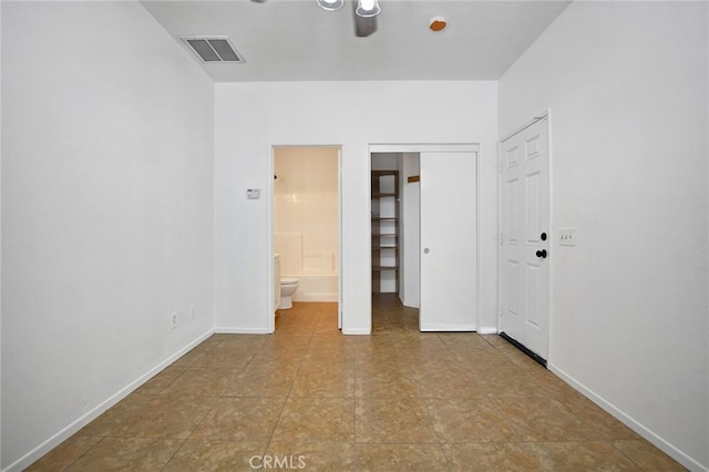 unfurnished bedroom featuring ensuite bathroom and a closet