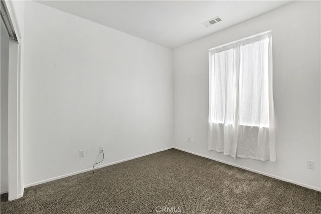 unfurnished room with dark carpet