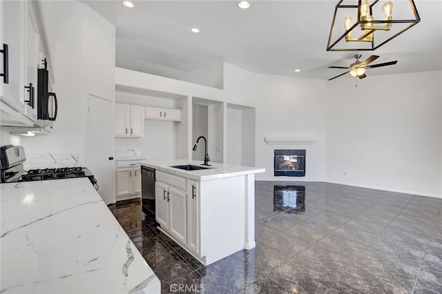 kitchen featuring white cabinets, a kitchen island with sink, black appliances, decorative light fixtures, and sink