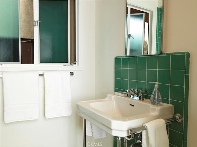 bathroom with sink and tasteful backsplash