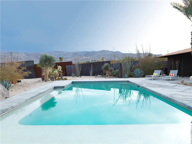 view of swimming pool with a mountain view and a patio