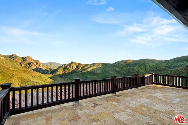 view of patio featuring a mountain view and a balcony