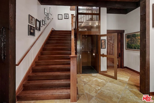 staircase with beamed ceiling