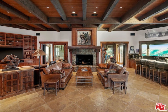 living room with beam ceiling, wood ceiling, and a fireplace