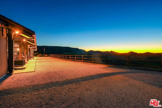 yard at dusk featuring a mountain view