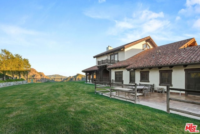 view of yard featuring a patio and a balcony