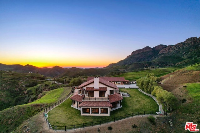 exterior space featuring a mountain view and a lawn