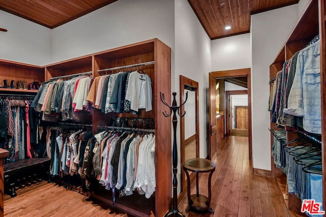 spacious closet featuring hardwood / wood-style flooring and a towering ceiling