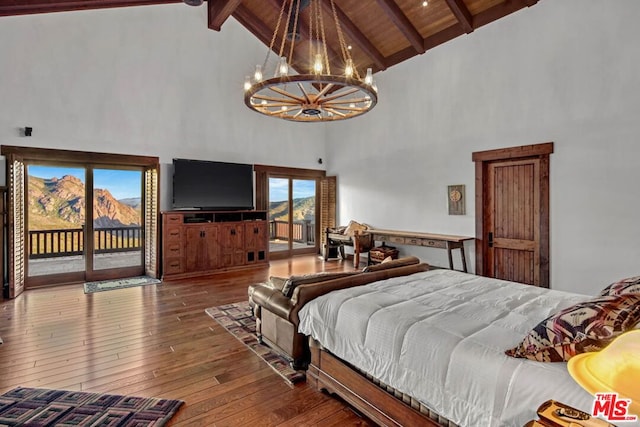 bedroom with access to exterior, hardwood / wood-style flooring, beam ceiling, a chandelier, and high vaulted ceiling