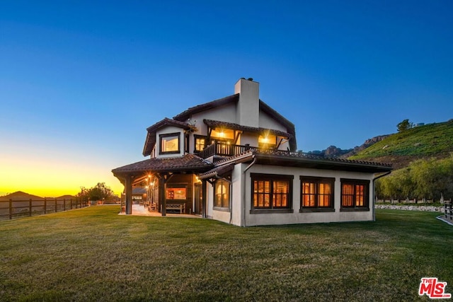 back house at dusk with a yard