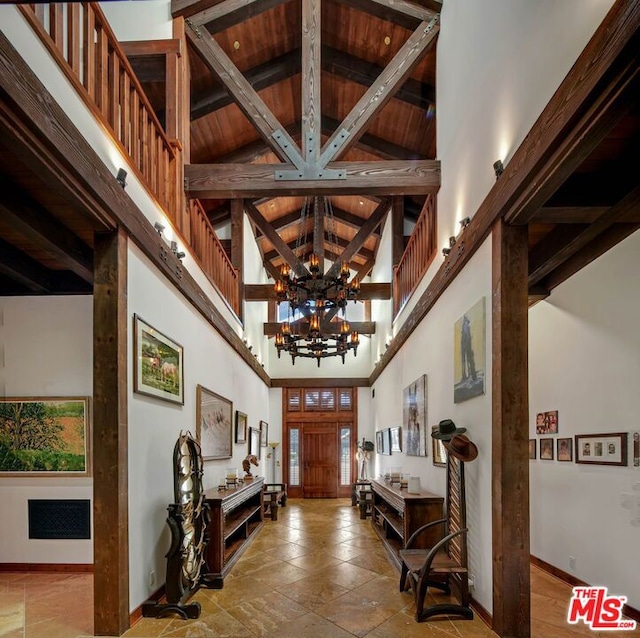 entrance foyer with an inviting chandelier, beamed ceiling, wood ceiling, and high vaulted ceiling