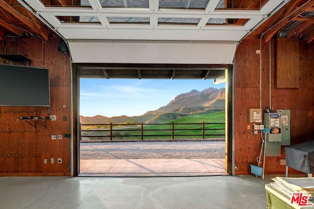 entryway with a mountain view, concrete flooring, and wooden walls