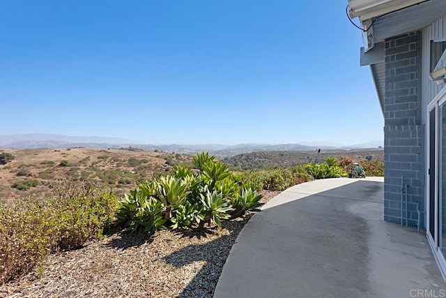 view of yard featuring a patio area and a mountain view