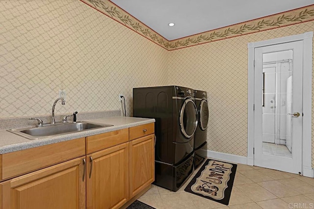 washroom with sink, independent washer and dryer, light tile patterned floors, and cabinets