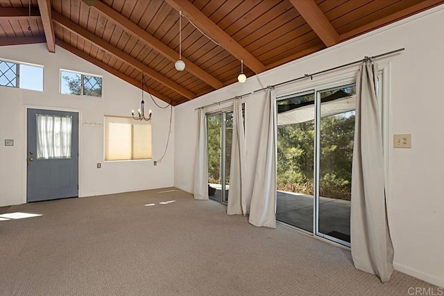 unfurnished living room featuring beam ceiling, wooden ceiling, carpet, and a wealth of natural light