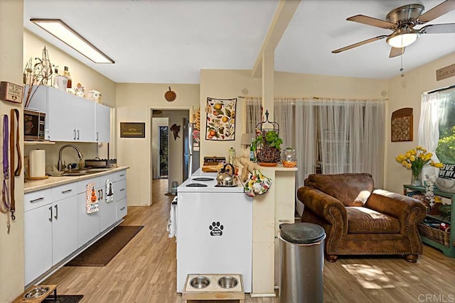 kitchen with white cabinets, electric range, ceiling fan, light hardwood / wood-style flooring, and sink