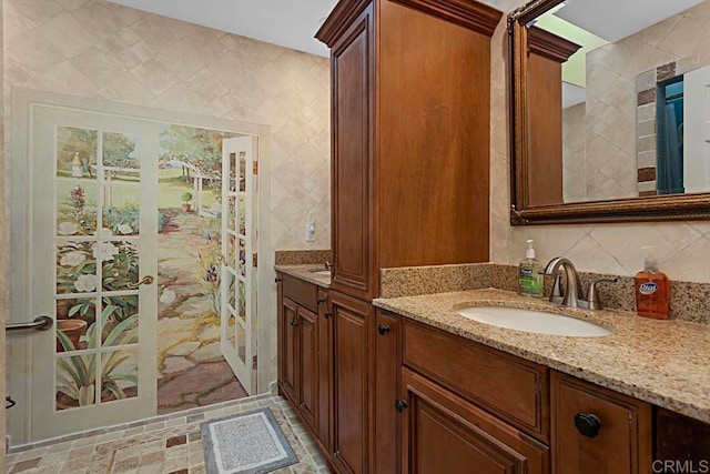 bathroom featuring vanity and tile walls