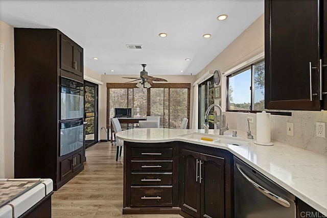 kitchen with dishwasher, sink, ceiling fan, light hardwood / wood-style floors, and tasteful backsplash