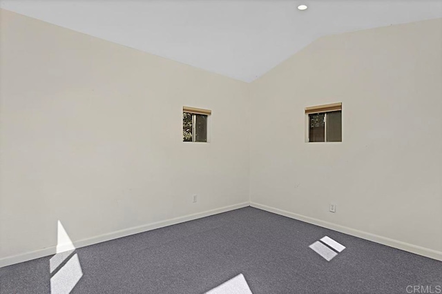 spare room featuring lofted ceiling and carpet