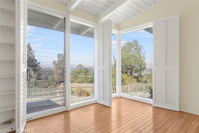 doorway featuring vaulted ceiling with beams, plenty of natural light, wood ceiling, and light hardwood / wood-style flooring