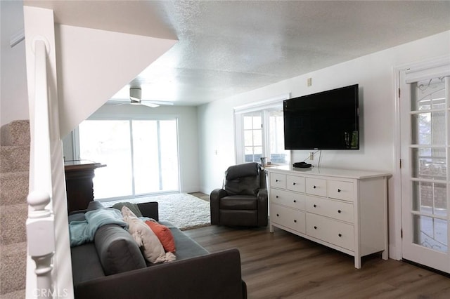 living room with ceiling fan, dark wood-type flooring, and a wealth of natural light