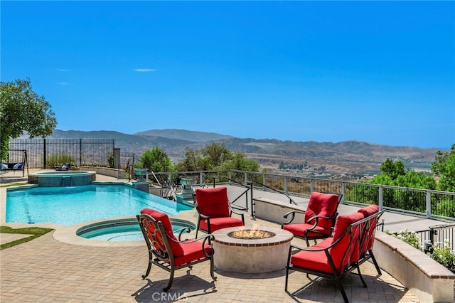 view of pool featuring an in ground hot tub, a mountain view, a patio, and a fire pit