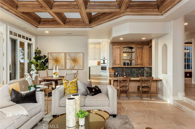 living room with coffered ceiling, ornamental molding, and beamed ceiling