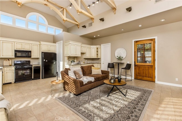 living room with a wealth of natural light, beamed ceiling, light tile patterned flooring, and high vaulted ceiling