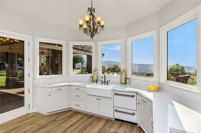 interior space with a notable chandelier, sink, a mountain view, and a healthy amount of sunlight